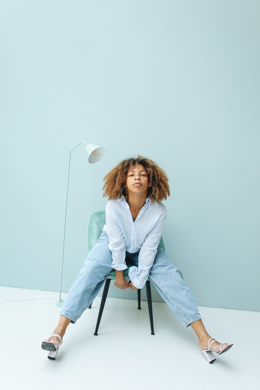 Person in a home office setting doing a seated neck stretch, bathed in cool blue light.